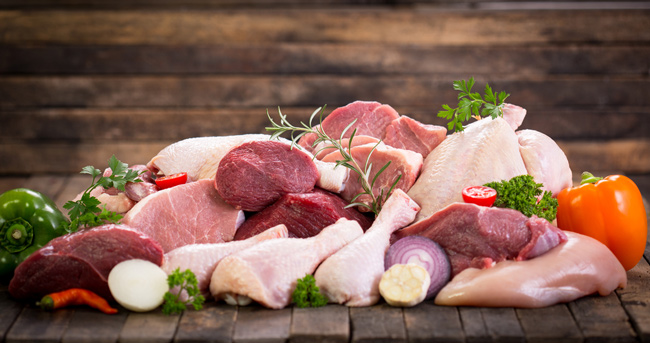 Different types of raw meat on a wooden table